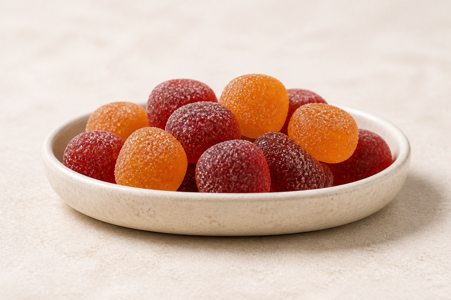 Red and orange MEND gummies in a ceramic dish.